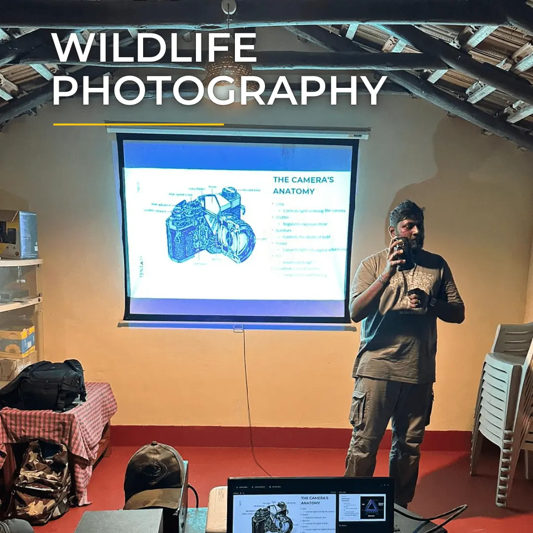 Wildlife photography instructor presenting camera anatomy in a workshop